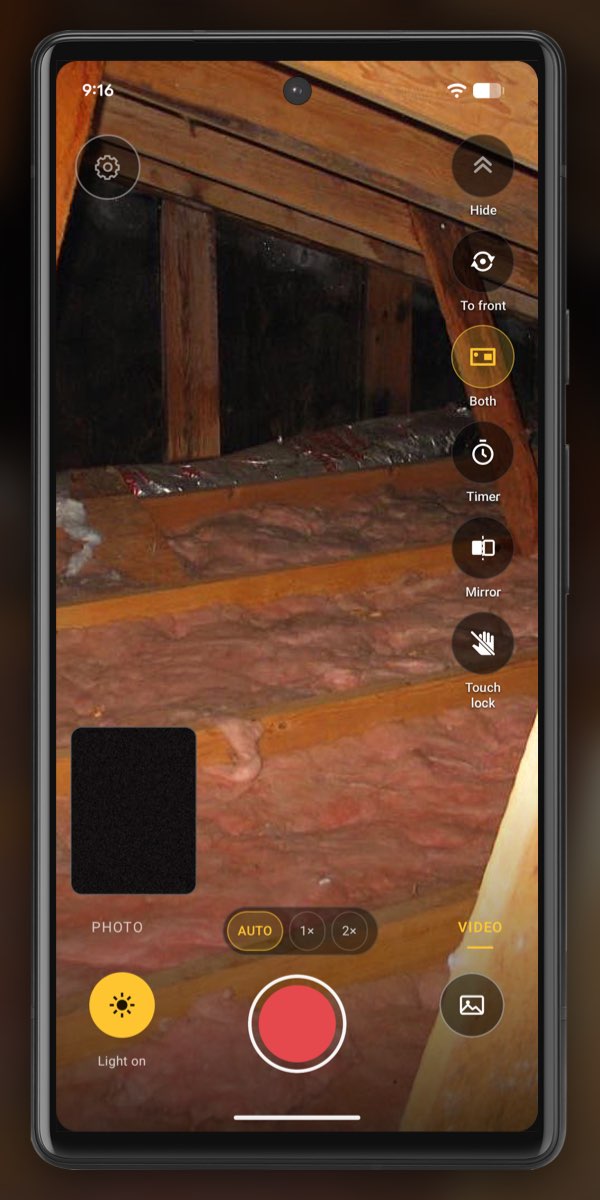 InspectCam in VIDEO mode with both cameras on in an attic: the rear camera, with Light on lit, shows rafters and pink insulation between the joists, and the front-camera window at the bottom left is dark.