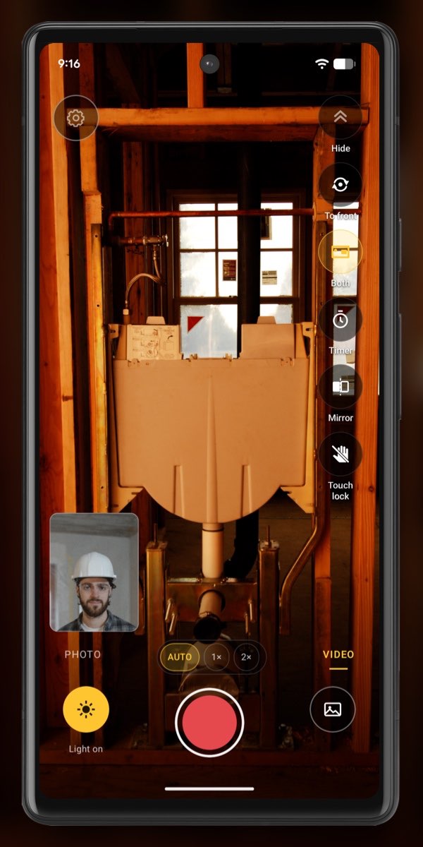 InspectCam’s Dual view: a bathroom rough-in on the back camera, the worker in a hard hat in a small front-camera window.