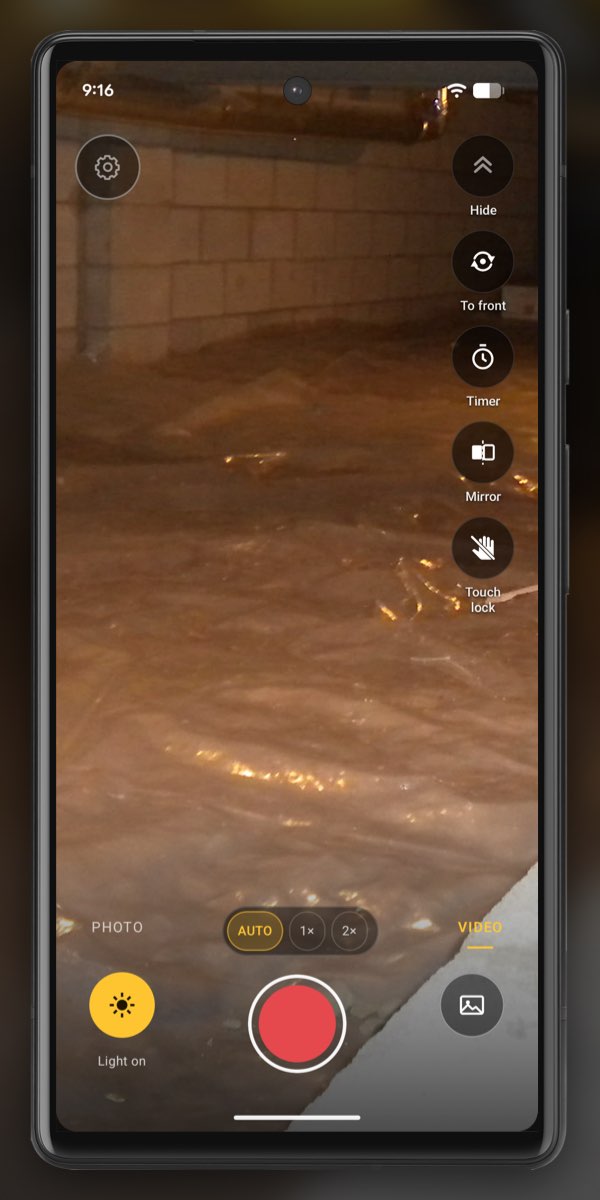 InspectCam in VIDEO mode looking across plastic sheeting on a crawl space floor toward a block wall, with Light on lit and the red record button.