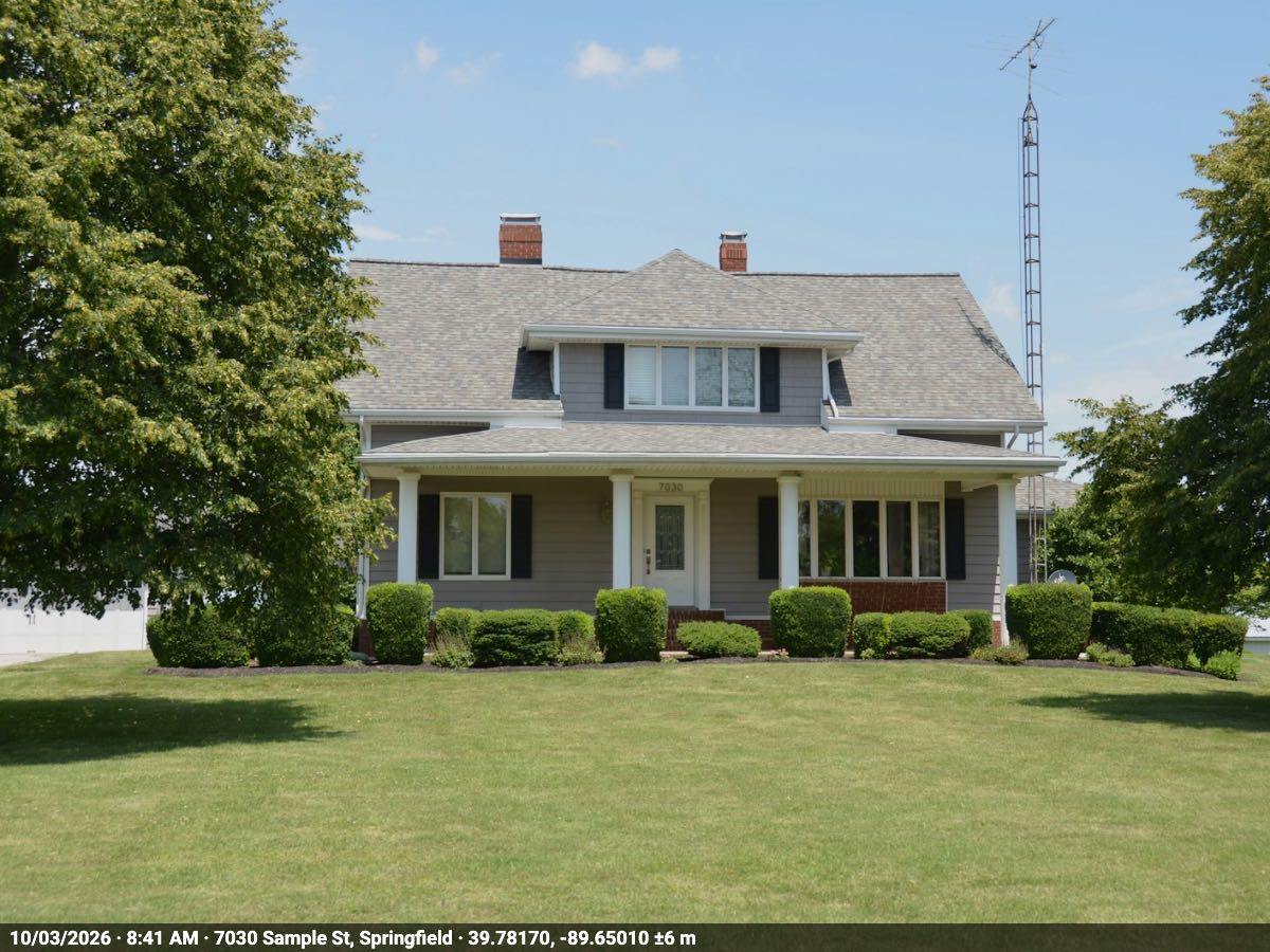The front of a gray two-story house with a porch, its house number over the front door, as a Front of property photo, with one thin dark strip along its bottom edge reading 10/03/2026 · 8:41 AM · 7030 Sample St, Springfield · 39.78170, -89.65010 ±6 m.