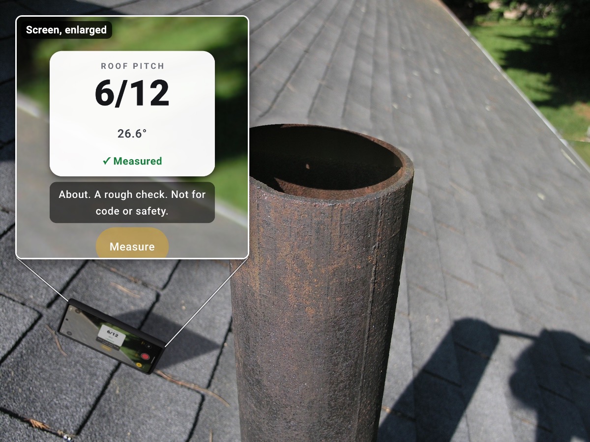 Illustration: a phone standing on its long side on an asphalt shingle roof, along the slope, beside a rusty roof vent, with the roof's edge and a lawn below in the far corner and the phone's shadow on the shingles. An enlarged inset of its screen shows a white card reading ROOF PITCH, 6/12, 26.6° and Measured with a green check, the rough-check line “About. A rough check. Not for code or safety.” and a lit Measure button.
