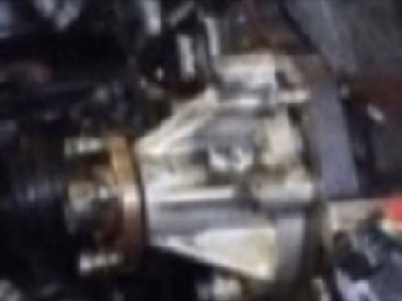 The same engine close-up, blurred so the bolts, threads and edges can no longer be made out.