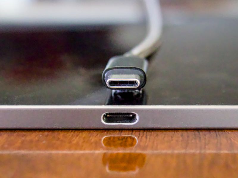 Close-up of the USB-C port on the edge of an iPad, with a USB-C plug lying just above it.